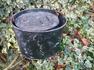An Antique Zinc Live Bait Kettle Early 20th Century sitting on the ground.